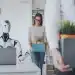 Robô sentado em frente a notebook enquanto pessoas carregam caixas, deixando o escritório.
