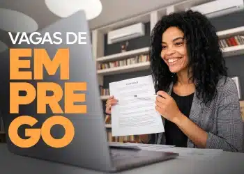 Mulher mexendo no notebook com expressão alegre.