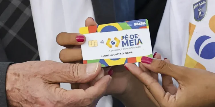 Estudante recebe cartão do programa Pé-de-Meia 2026 do governo federal.