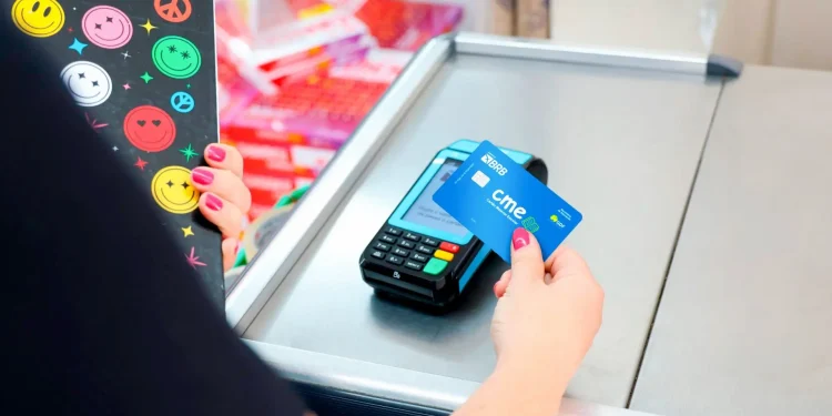 Pagamento de material escolar com cartão do benefício educacional em caixa de papelaria.