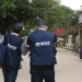 Dois recenseadores do IBGE caminham juntos em rua de vila para coleta de informações
