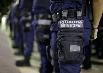 Guardas municipais perfilados usando uniforme azul marinho e equipamento tático com identificação Guarda Municipal