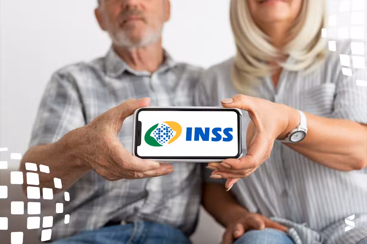 Casal de aposentados mostrando o logo do INSS em um celular.