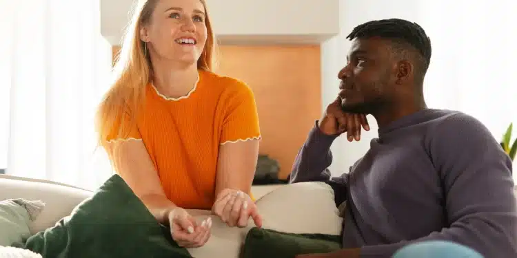 Casal conversando em um ambiente confortável, com um deles sorrindo e o outro observando atentamente.
