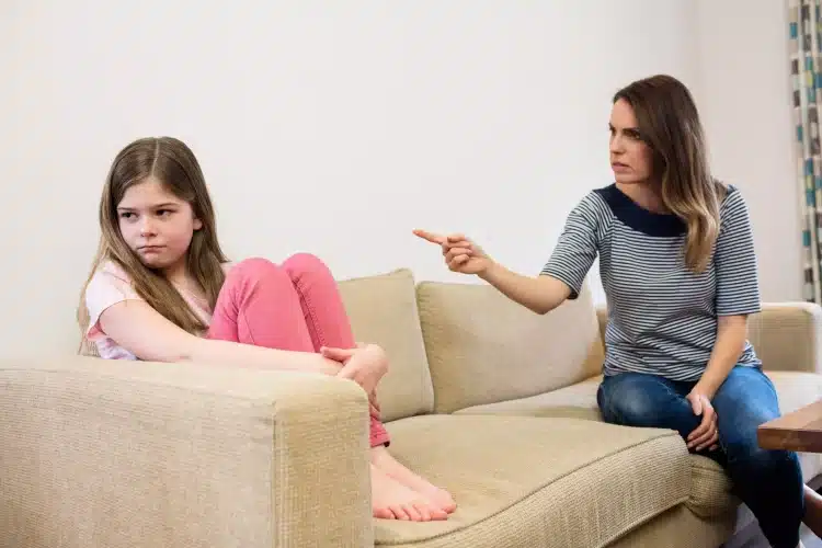 Mãe apontando para a filha, que parece triste e frustrada, simbolizando a dinâmica de pais tóxicos e seu impacto emocional.