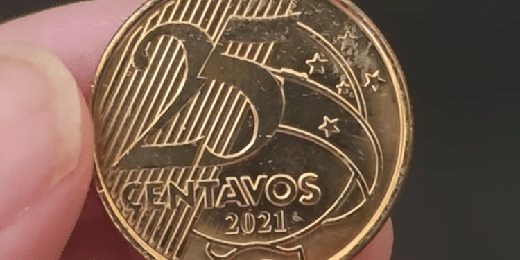 Close-up de uma moeda brasileira de 25 centavos do ano de 2021 sendo segurada, mostrando o valor e o ano em alto relevo, ideal para identificação de erros.
