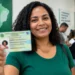 Mulher segura a nova Carteira de Identidade, representando o mutirão de emissão do documento com atendimento por ordem de chegada em Campo Grande.