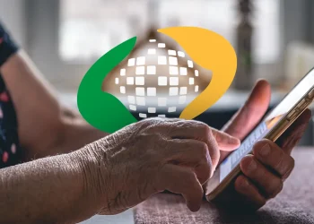 Mãos envelhecidas segurando e usando um smartphone com o logotipo do mundo digital ao fundo