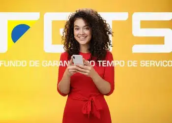 Trabalhadora consultando aplicativo do FGTS no celular para verificar liberação do Saque-Aniversário em fevereiro