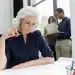 Mulher madura analisando documentos com foco e experiência, representando profissionais acima dos 40 anos no mercado de trabalho.
