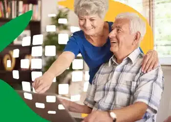 Casal de idosos sorrindo enquanto utilizam um laptop, representando a importância do INSS na vida dos aposentados.