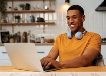 Jovem utilizando notebook para estudar tecnologia em curso online de qualificação profissional.