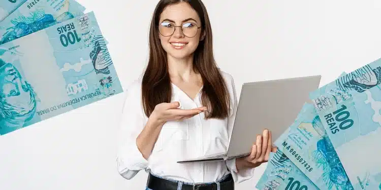 Mulher sorrindo segura notebook e aponta para frente com notas de cem reais ao redor.