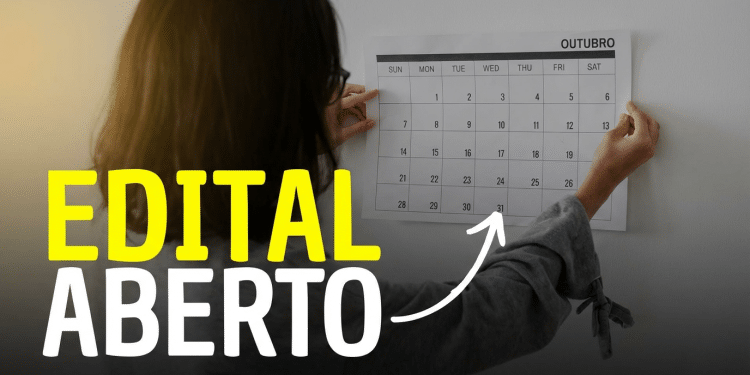 Pessoa marca datas no calendário de outubro em parede branca indicando abertura de edital