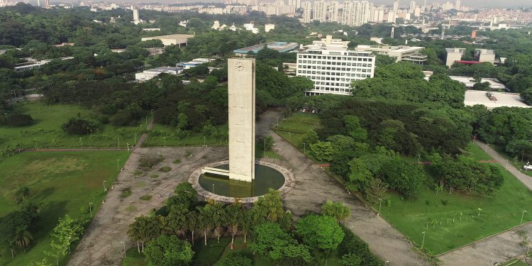 Vista aérea do Relógio da USP cercado por áreas verdes e prédios no campus