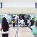 Candidatos entrando em local de prova com placas de entrada e saída visíveis representando o dia de aplicação das provas do concurso do IBGE 2026