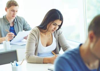 Candidatos realizando prova em sala de aula representando novos editais com inscrições em abril e salários de até R$ 5,3 mil
