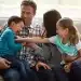 Família brincando juntos no sofá, representando os comportamentos comuns em adultos que foram o filho favorito durante a infância.