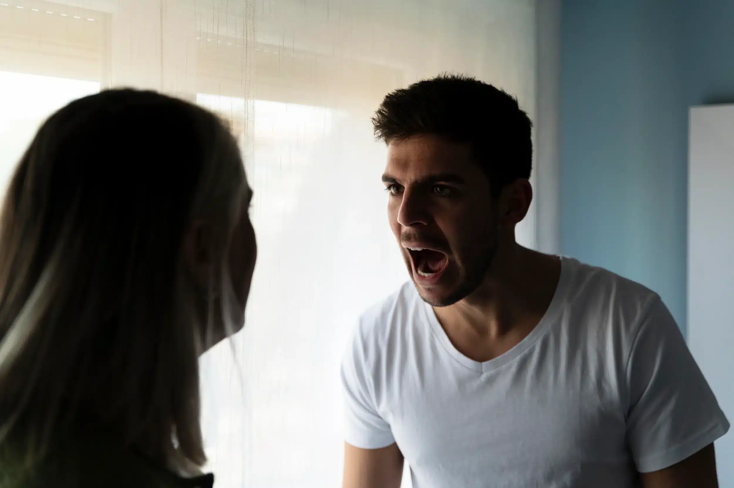 Homem gritando para uma mulher em um momento de tensão, representando a violência psicológica do gaslighting em um relacionamento.