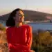Mulher sorrindo ao ar livre durante o pôr do sol representando hábitos positivos para uma vida mais equilibrada.