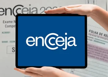 Imagem do logotipo do Encceja 2026, com fundo azul e mãos segurando um tablet mostrando o logo, destacando a importância da inscrição para o exame.