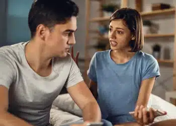 Mulher expressando sentimentos enquanto homem escuta em conversa séria na sala de casa