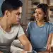 Mulher expressando sentimentos enquanto homem escuta em conversa séria na sala de casa
