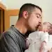 Pai segurando e beijando um recém-nascido, representando o fortalecimento do vínculo familiar após aprovação do Senado para ampliar gradualmente a licença paternidade no Brasil.