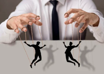 Imagem ilustrativa de uma pessoa manipuladora controlando duas silhuetas, simbolizando manipulação e controle sobre os outros.