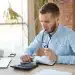 Homem analisando contas e fazendo cálculos financeiros no notebook para negociar dívidas bancárias no mutirão de renegociação