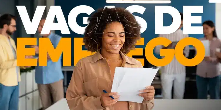 Mulher negra sorridente segurando currículos em papel em um escritório moderno, com o texto "VAGAS DE EMPREGO" sobreposto em letras grandes nas cores branco e laranja.