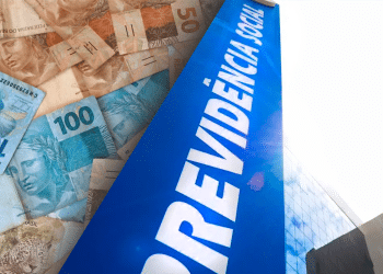 Cédulas de reais ao lado de prédio com letreiro Previdência Social em destaque, simbolizando os pagamentos do 13º salário do INSS.