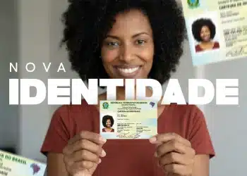 Mulher segurando a nova Carteira de Identidade Nacional com outros documentos de identidade ao fundo