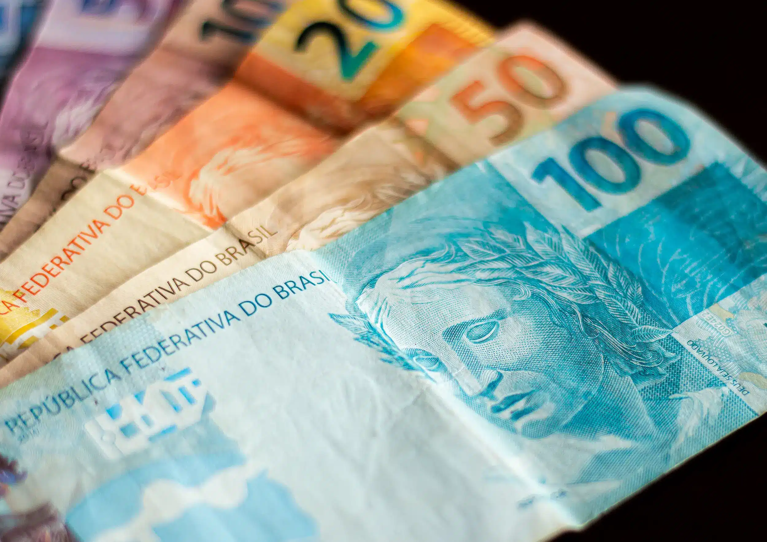 Notas de reais em diferentes valores, ilustrando o programa Pé-de-Meia, que fará repasses a partir de 27 de abril.