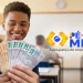 Estudante comemorando com as mãos cheias de notas de dinheiro do programa Pé-de-Meia, representando o incentivo financeiro de R$ 2.200 para estudantes.