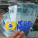 Notas de R$ 100 e R$ 50 empilhadas com o logo do programa Pé-de-Meia Licenciaturas, representando o primeiro pagamento de R$ 1.050.