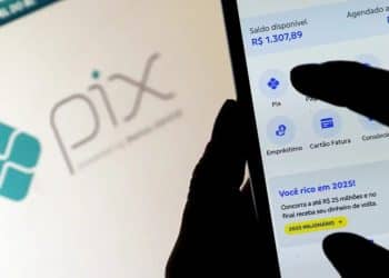Mão segurando celular com aplicativo do Pix aberto ao lado da logomarca do Pix — Pix funciona na Sexta-Feira Santa 2026