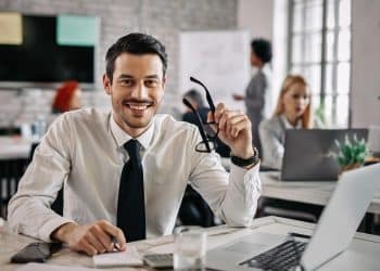 Profissional sorridente de terno em escritório moderno — destaques entre as profissões mais bem remuneradas com salários de até R$ 50 mil por mês