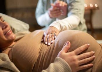 Doula realizando técnica de conforto em gestante durante acompanhamento humanizado no período pré-parto.