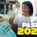 Mulher sorrindo segurando notas de cinquenta e cem reais com calendário de pagamentos