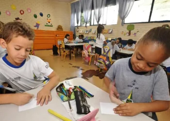 Alunos do ensino fundamental realizam atividades em sala de aula em escola pública.