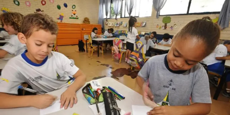 Alunos do ensino fundamental realizam atividades em sala de aula em escola pública.