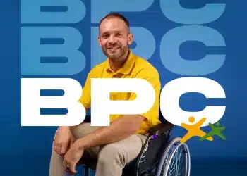 Homem sorrindo em cadeira de rodas com camiseta amarela, representando o Benefício de Prestação Continuada (BPC), com o logo do programa ao fundo.
