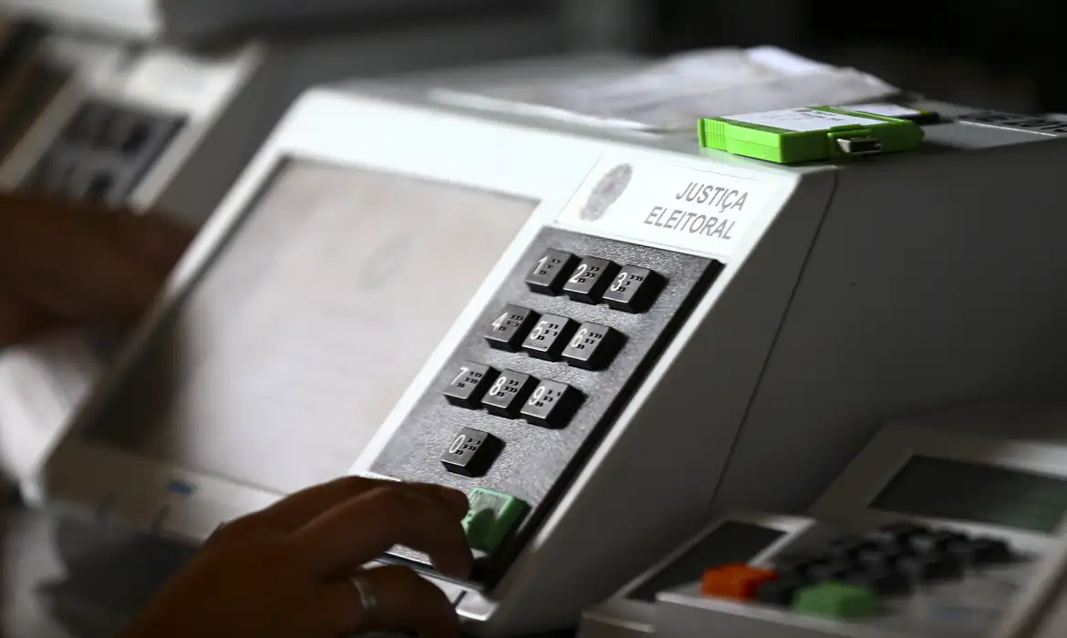 Mesário utilizando a urna eletrônica durante o processo de votação nas eleições.
