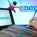 Estudante anotando em caderno enquanto acessa informações do Enem em notebook.