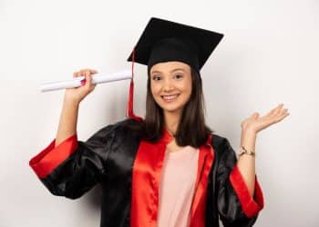 Jovem formanda celebra conquista do diploma com sorriso.