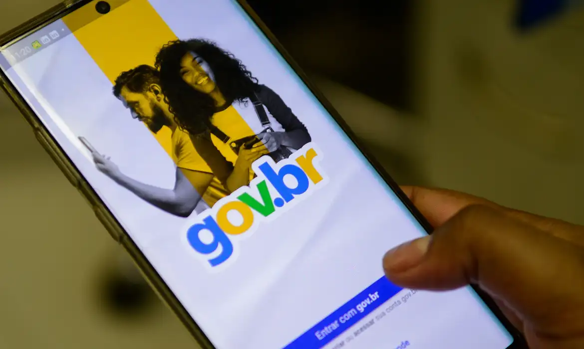 Pessoa segurando smartphone com a tela de login da plataforma Gov.br aberta para acesso à conta