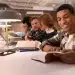 Estudantes concentrados em leitura e estudo em grupo representando o aulão solidário do Enem com preparação intensiva