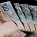 Notas de real brasileiro organizadas simbolizando pagamento do auxílio-creche de R$ 526,64 para novos beneficiários.