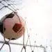 Bola de futebol entrando no gol representando oportunidades de carreira no futebol fora das quatro linhas